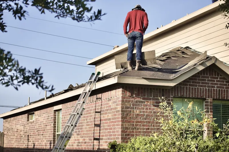 Professional roofer working on a residential roof in Estell Manor